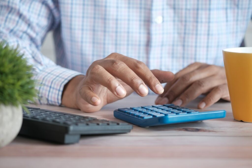 Person using calculator at desk with paperwork