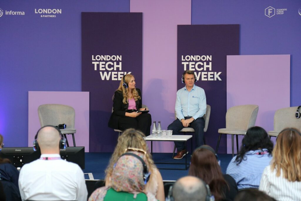Two speakers on stage at a London tech industry event