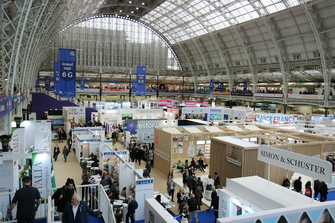 Busy exhibition hall with many booths and attendees at a large conference