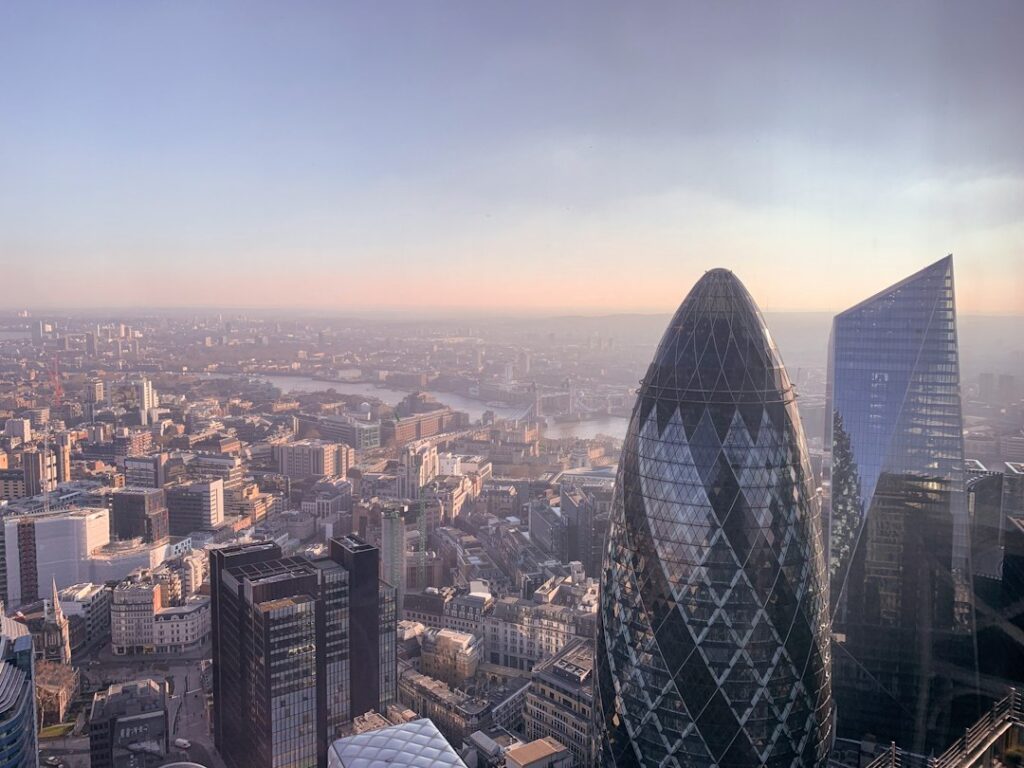 The London financial district skyline at dusk, highlighting the Gherkin building and corporate offices.